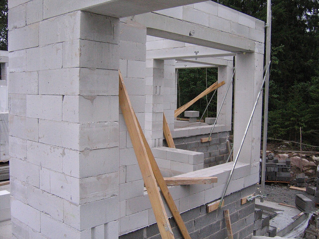 A house wall being built from white AAC green blocks