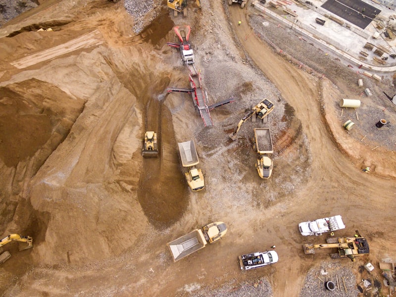 Aerial view of a construction earthworks site with delivery trucks