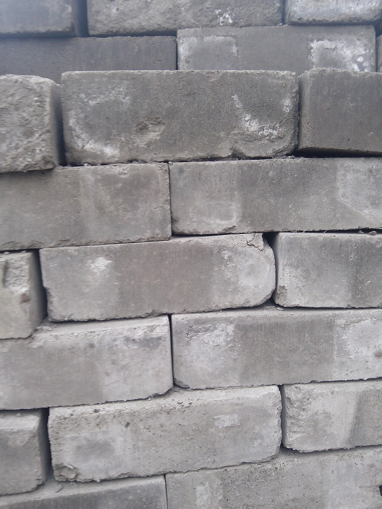 Close-up of stacked grey cement bricks