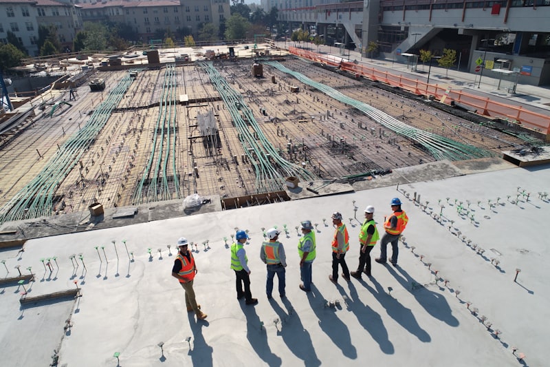 A construction team in hard hats on a large concrete slab